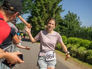 eine Läuferin gibt High Fives entlang der Strecke beim Lauf zwischen den Meeren